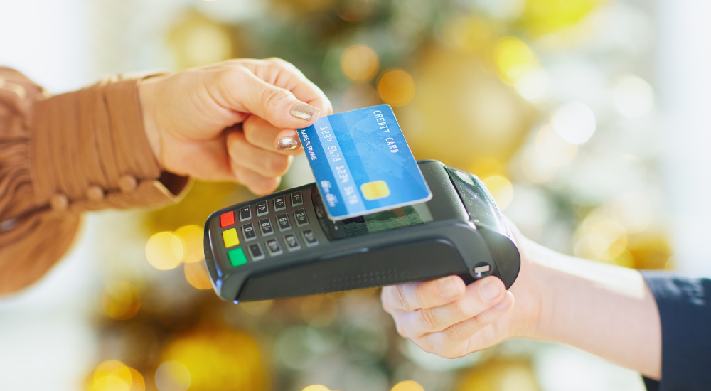 店舗でクレジットカードを決済端末にかざしてキャッシュレス決済を行っている画像で、【店舗システム(お会計)】を示し、スムーズで非接触の会計処理がクライアントの負担やストレスを軽減し、スマートで利便性の高いサービスを提供している様子。
